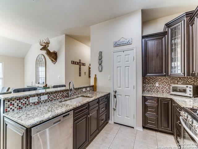 kitchen featuring dark brown cabinetry, sink, stainless steel appliances, kitchen peninsula, and light tile patterned flooring