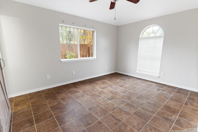 tiled empty room featuring ceiling fan