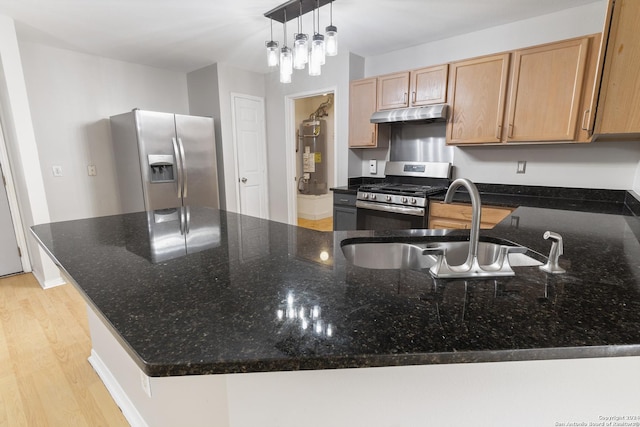 kitchen featuring light hardwood / wood-style floors, sink, appliances with stainless steel finishes, and dark stone counters