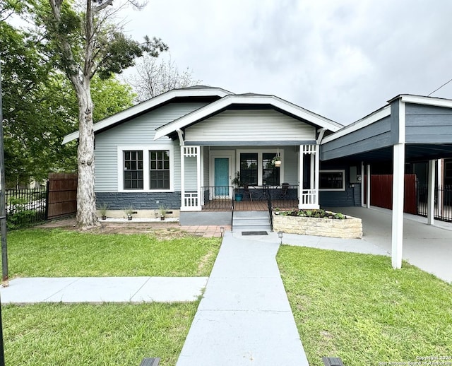 view of front of home with a front lawn, a porch, and a carport