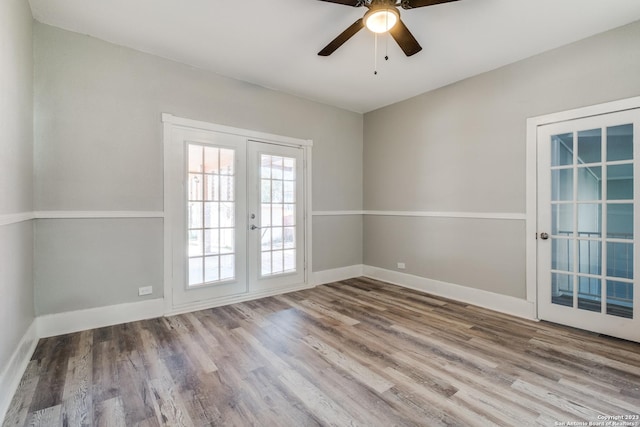 empty room with hardwood / wood-style flooring, ceiling fan, and french doors