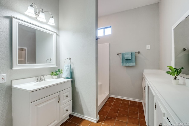 bathroom featuring vanity, tile patterned flooring, and a shower