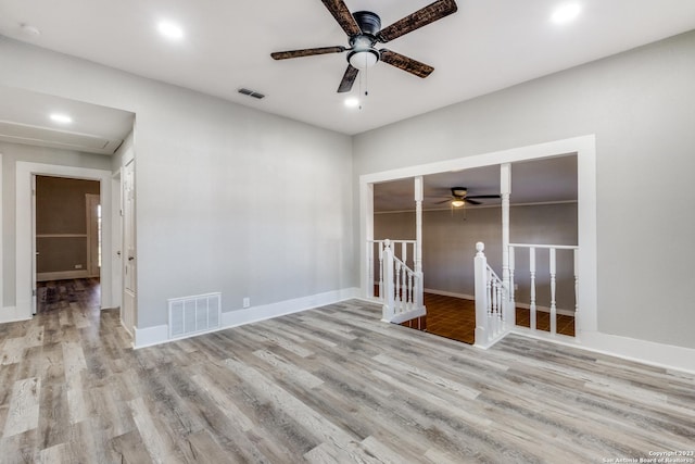 empty room with ceiling fan and light hardwood / wood-style flooring