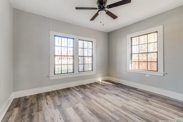 empty room with ceiling fan, a healthy amount of sunlight, and light hardwood / wood-style flooring