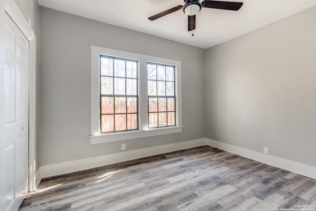 spare room with ceiling fan and light wood-type flooring