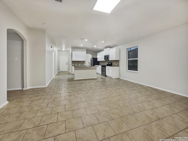 unfurnished living room featuring light tile patterned floors, sink, and vaulted ceiling