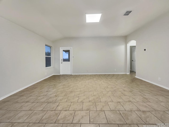 unfurnished room with vaulted ceiling