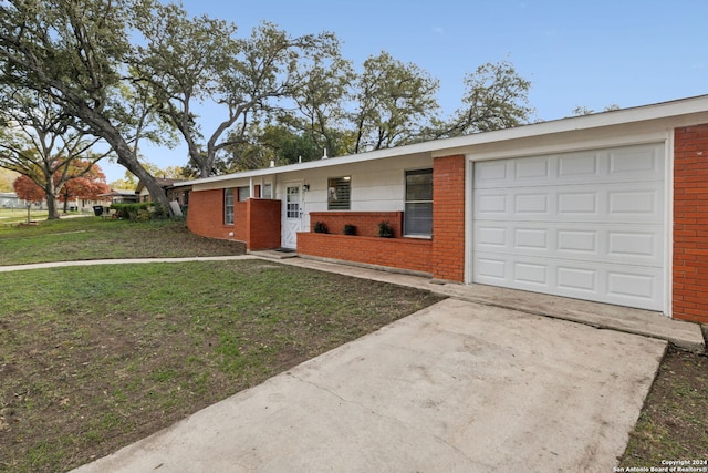 single story home with a garage and a front lawn