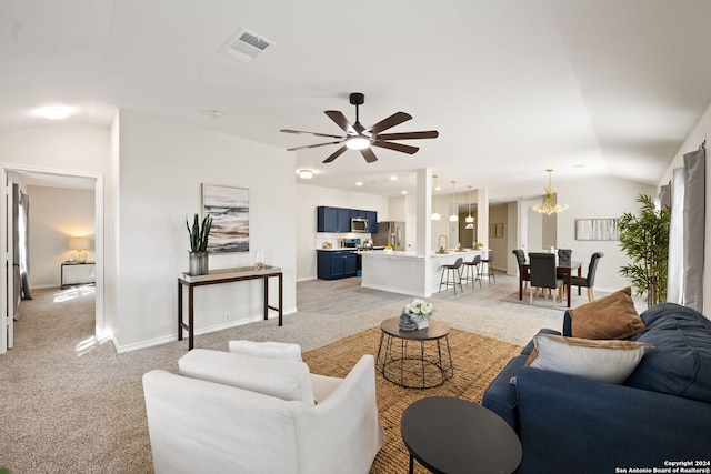 carpeted living room featuring ceiling fan with notable chandelier and lofted ceiling