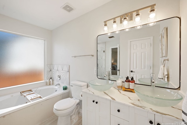 bathroom with a bathtub, toilet, and vanity