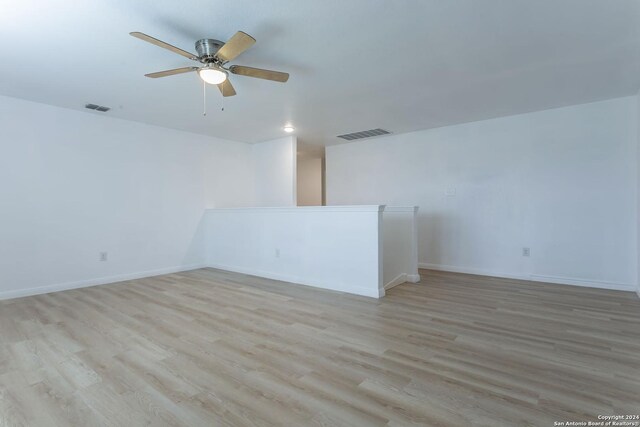 empty room with light hardwood / wood-style flooring and ceiling fan