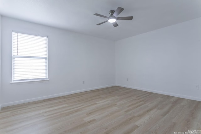 unfurnished room with ceiling fan, light wood-type flooring, and a wealth of natural light