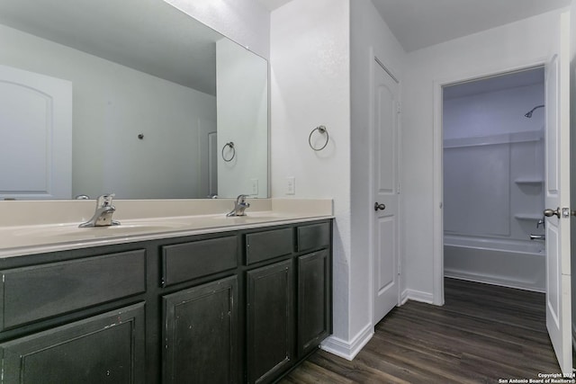 bathroom featuring washtub / shower combination, wood-type flooring, and vanity