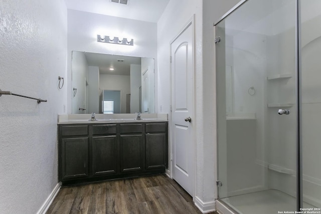 bathroom with hardwood / wood-style floors, vanity, and an enclosed shower