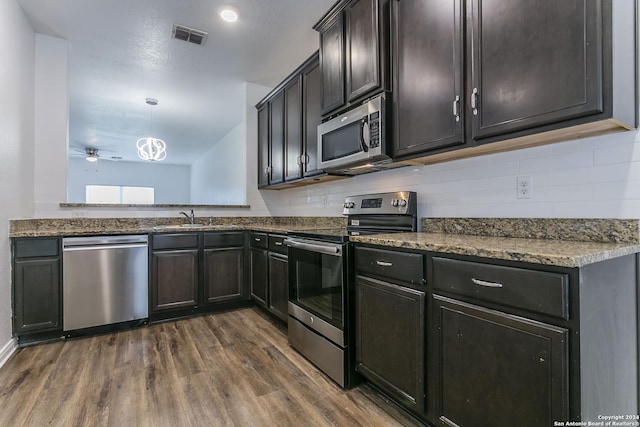 kitchen featuring ceiling fan, sink, dark wood-type flooring, pendant lighting, and appliances with stainless steel finishes