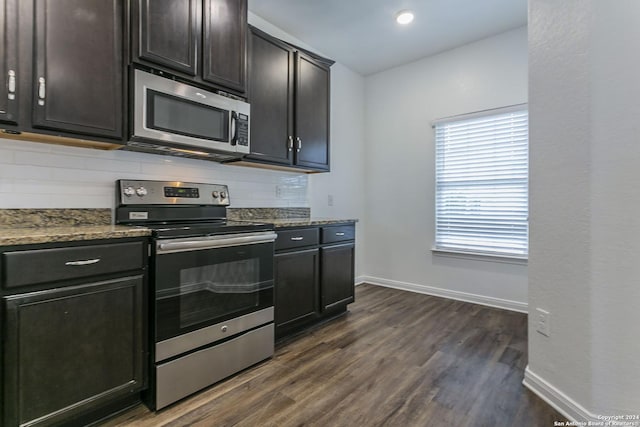 kitchen featuring dark hardwood / wood-style floors, tasteful backsplash, appliances with stainless steel finishes, and dark stone counters