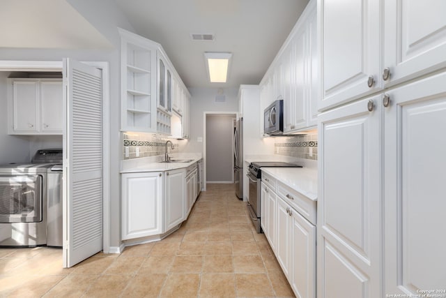 kitchen featuring white cabinetry, sink, tasteful backsplash, light tile patterned flooring, and appliances with stainless steel finishes