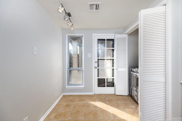 doorway to outside with light tile patterned flooring