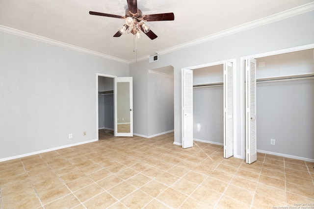 unfurnished bedroom featuring ceiling fan, crown molding, and two closets