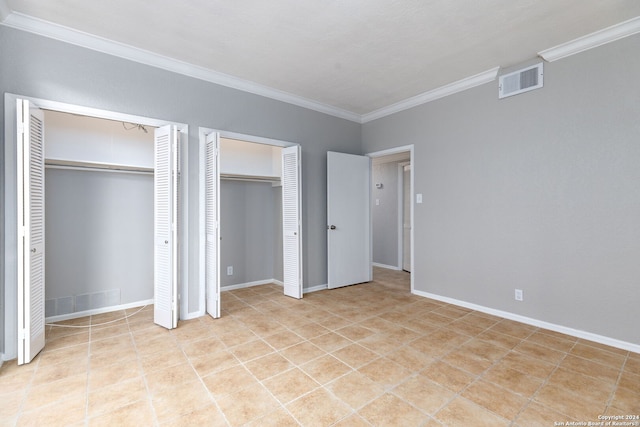 unfurnished bedroom with two closets and ornamental molding