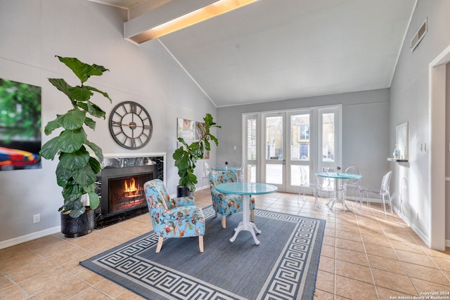 interior space with beamed ceiling, a fireplace, and high vaulted ceiling