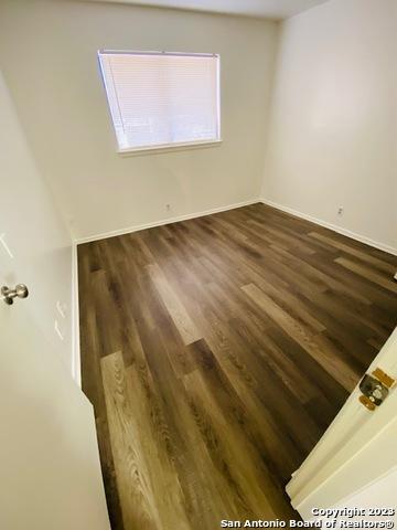 unfurnished room with dark hardwood / wood-style floors