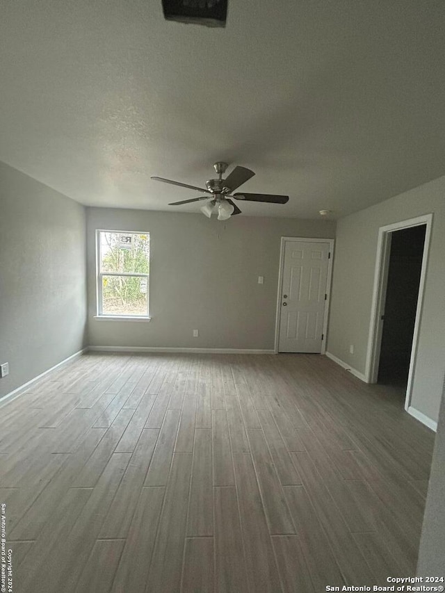 empty room featuring ceiling fan, wood-type flooring, and a textured ceiling