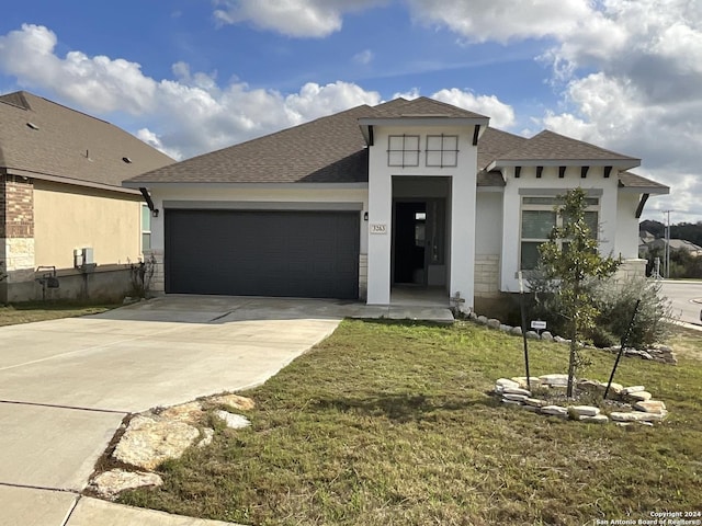 view of front facade featuring a front yard and a garage