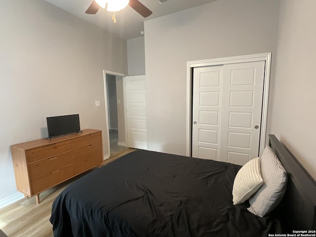 bedroom with light hardwood / wood-style floors, a closet, and ceiling fan