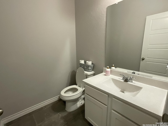 bathroom with tile patterned flooring, vanity, and toilet