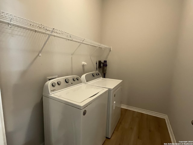 washroom with hardwood / wood-style flooring and washing machine and clothes dryer