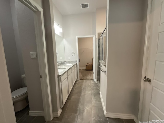 bathroom featuring an enclosed shower, vanity, and toilet