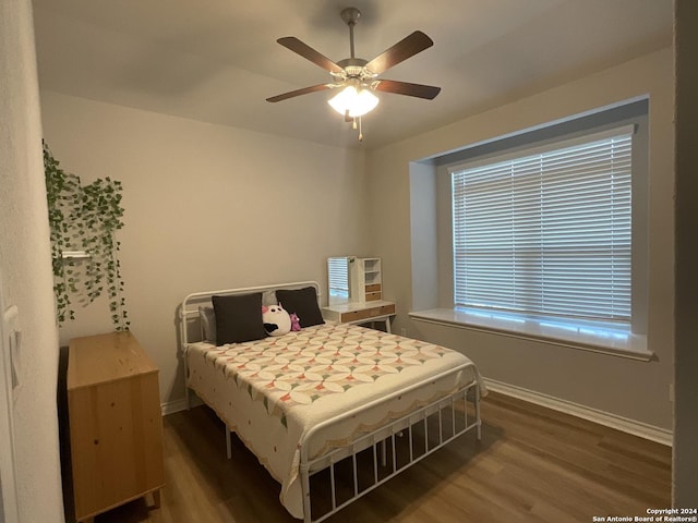 bedroom with dark hardwood / wood-style floors and ceiling fan