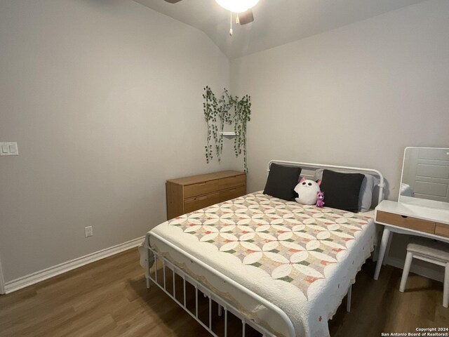 bedroom with vaulted ceiling, ceiling fan, and dark wood-type flooring