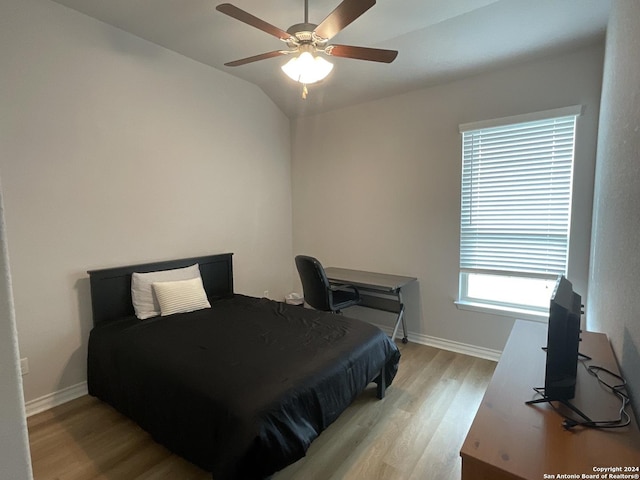 bedroom featuring ceiling fan, light hardwood / wood-style floors, and vaulted ceiling