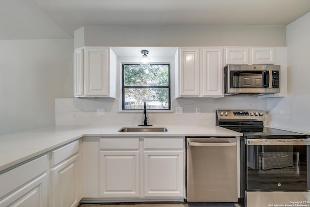 kitchen featuring decorative backsplash, white cabinetry, sink, and appliances with stainless steel finishes