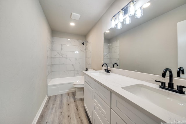 full bathroom with vanity, toilet, tiled shower / bath, and hardwood / wood-style flooring