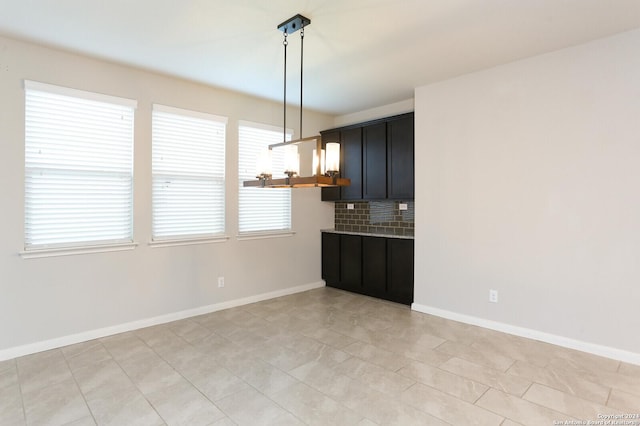 kitchen featuring tasteful backsplash, light tile patterned flooring, and pendant lighting