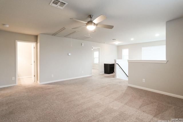 empty room featuring ceiling fan and light colored carpet