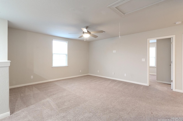 carpeted spare room featuring a wealth of natural light and ceiling fan