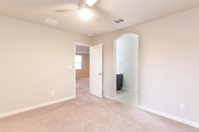 empty room featuring ceiling fan and light colored carpet