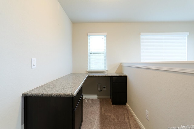 home office with built in desk and dark carpet