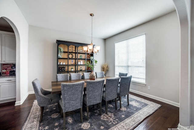 dining area featuring dark wood-type flooring and a chandelier