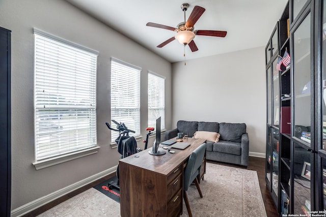 home office with dark hardwood / wood-style floors, ceiling fan, and a healthy amount of sunlight