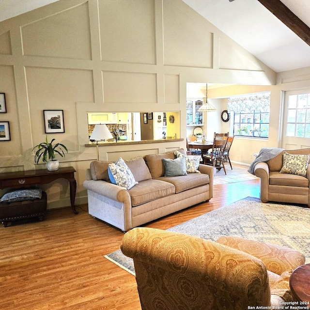 living room featuring light wood-type flooring and high vaulted ceiling