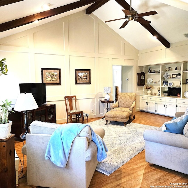 living room featuring vaulted ceiling with beams, ceiling fan, and light wood-type flooring