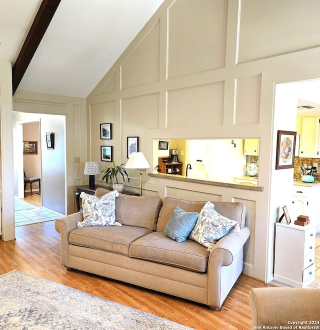 living room with beam ceiling and light hardwood / wood-style flooring