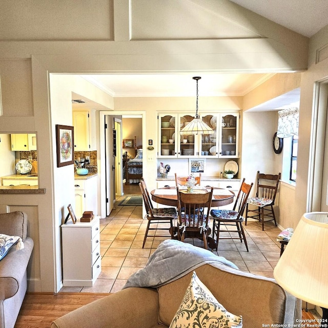 dining area featuring light hardwood / wood-style floors and ornamental molding