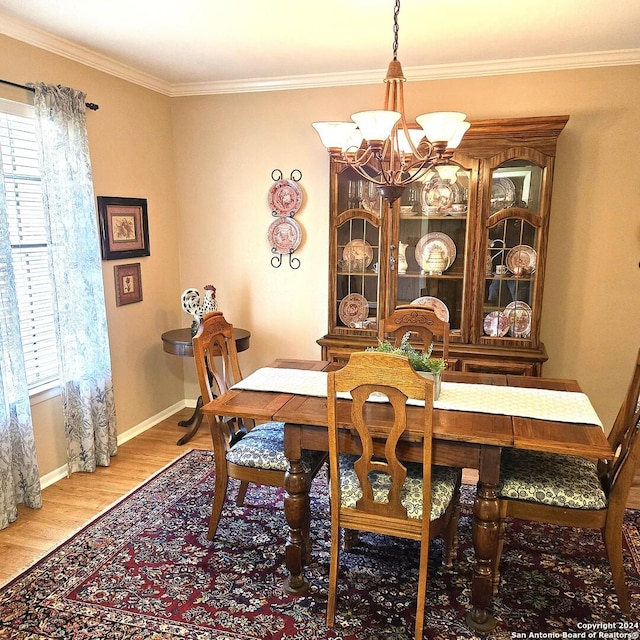 dining space featuring crown molding, an inviting chandelier, and hardwood / wood-style flooring