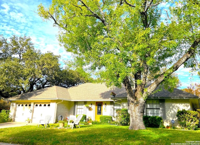 single story home featuring a front yard and a garage